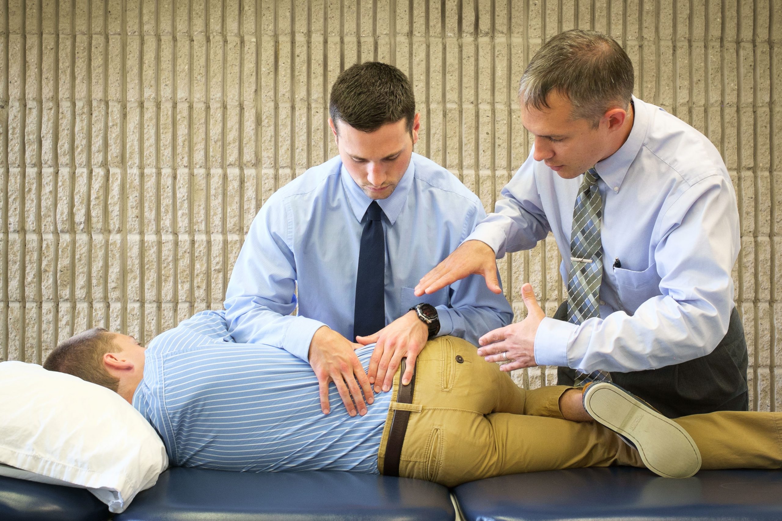 demonstrating a physical therapy exercise with faculty supervision