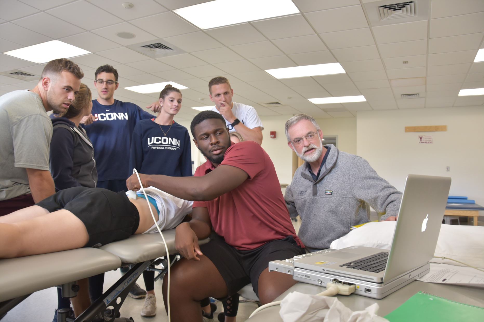 demonstrating a physical therapy exercise with faculty supervision