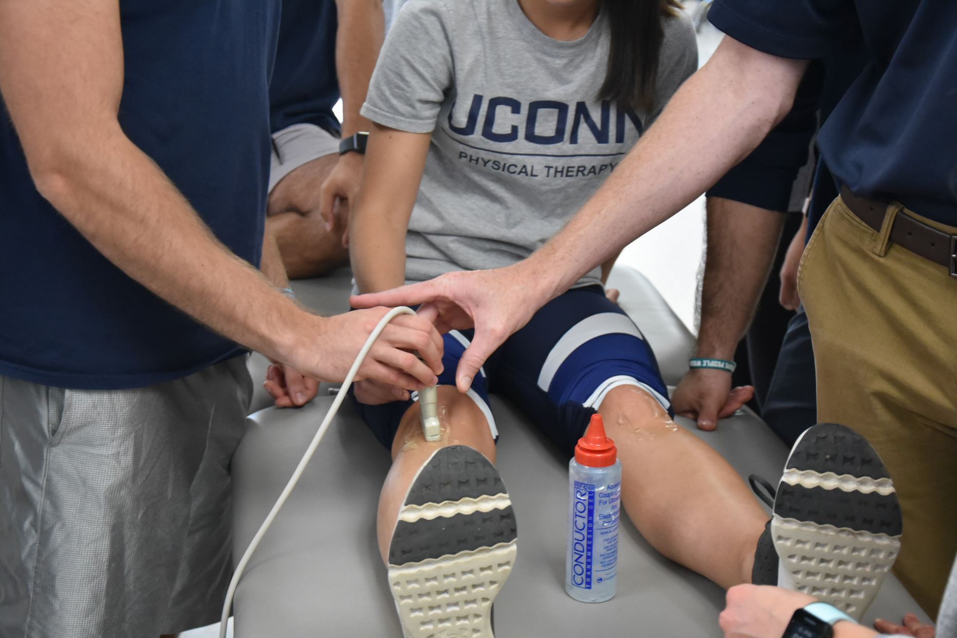 demonstrating a physical therapy exercise with faculty supervision