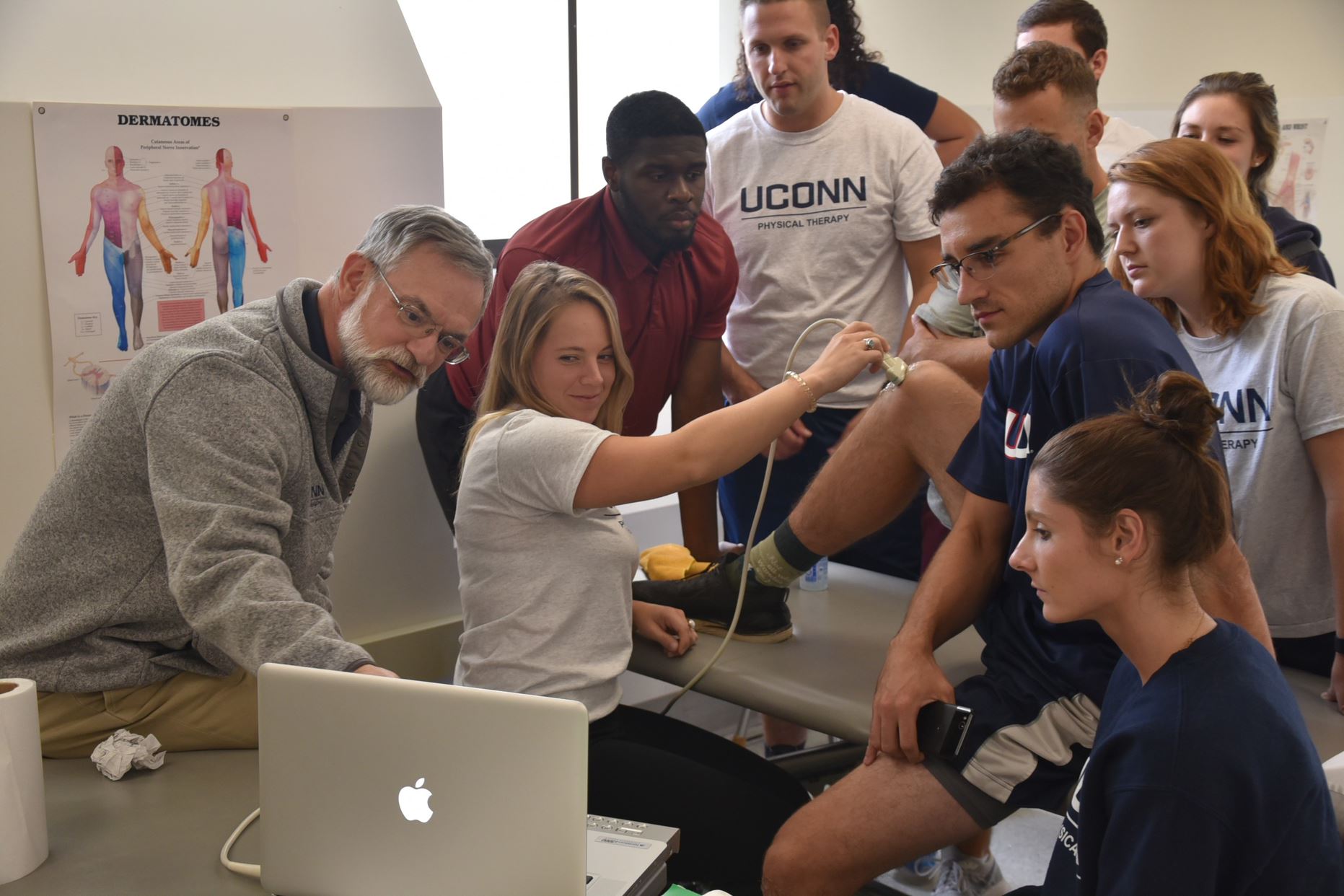 demonstrating a physical therapy exercise with faculty supervision